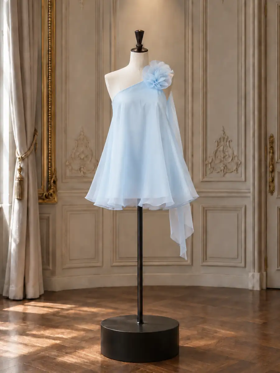 Pale blue organza one-shoulder mini with a rosette, on a mannequin