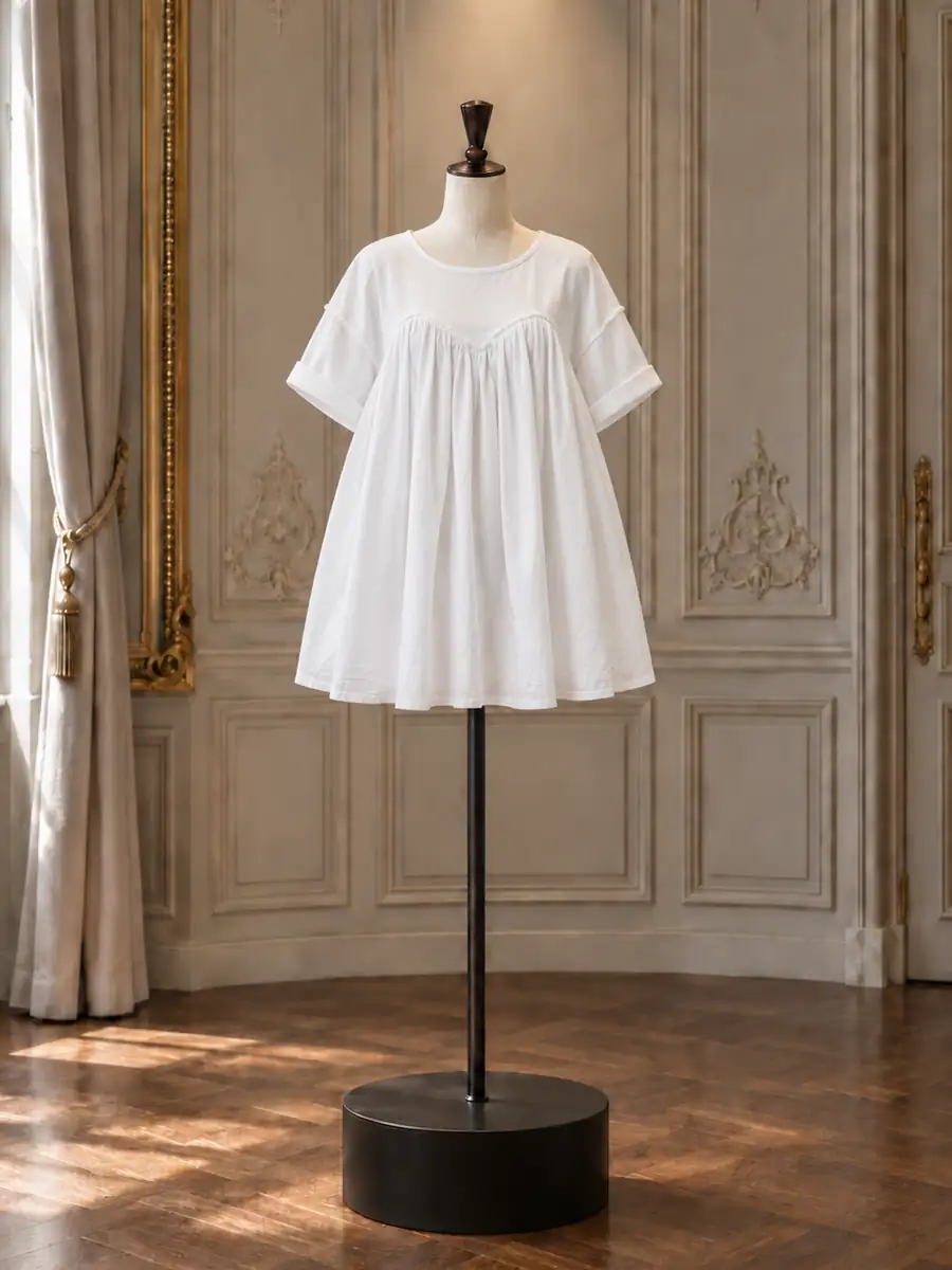 White cotton smocked short-sleeve babydoll mini, on a mannequin