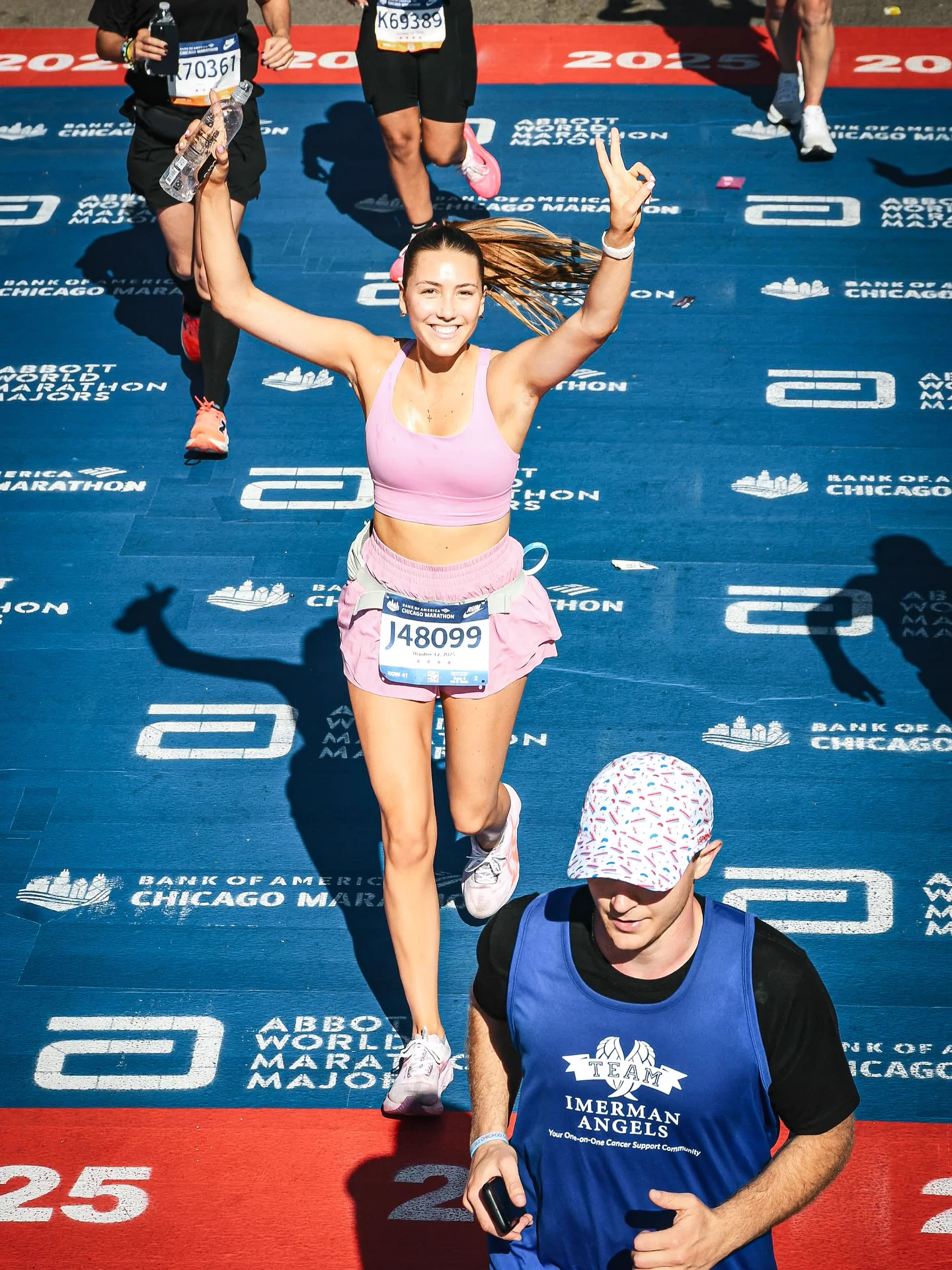 Lindi crossing the Chicago Marathon finish line with both arms raised